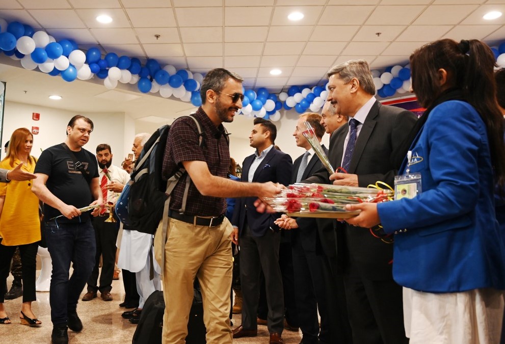پاکستانی حکام اسلام آباد ایئرپورٹ پر مسافروں کو پھولوں سے خوش آمدید کہہ رہے ہیں۔